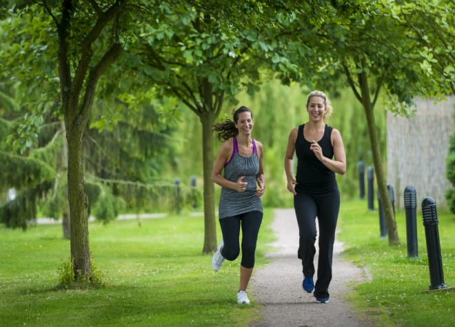 Two ladies running through Ragdale Hall grounds
