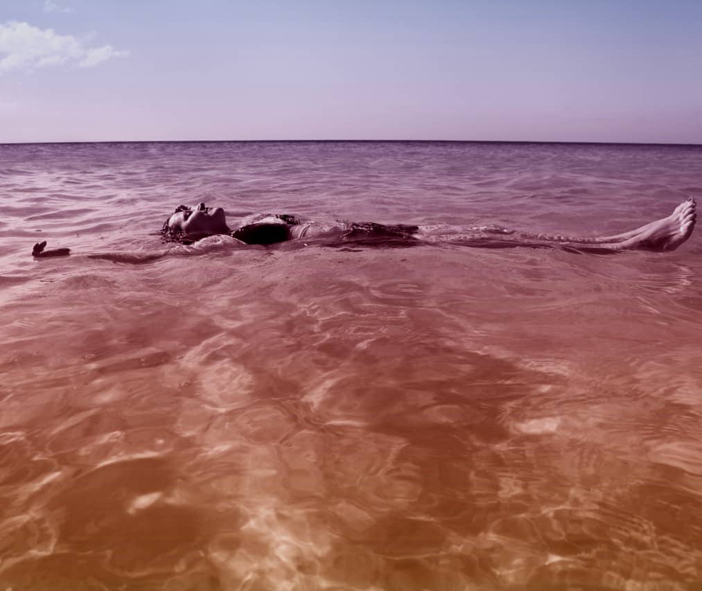Lady floating happily in sea
