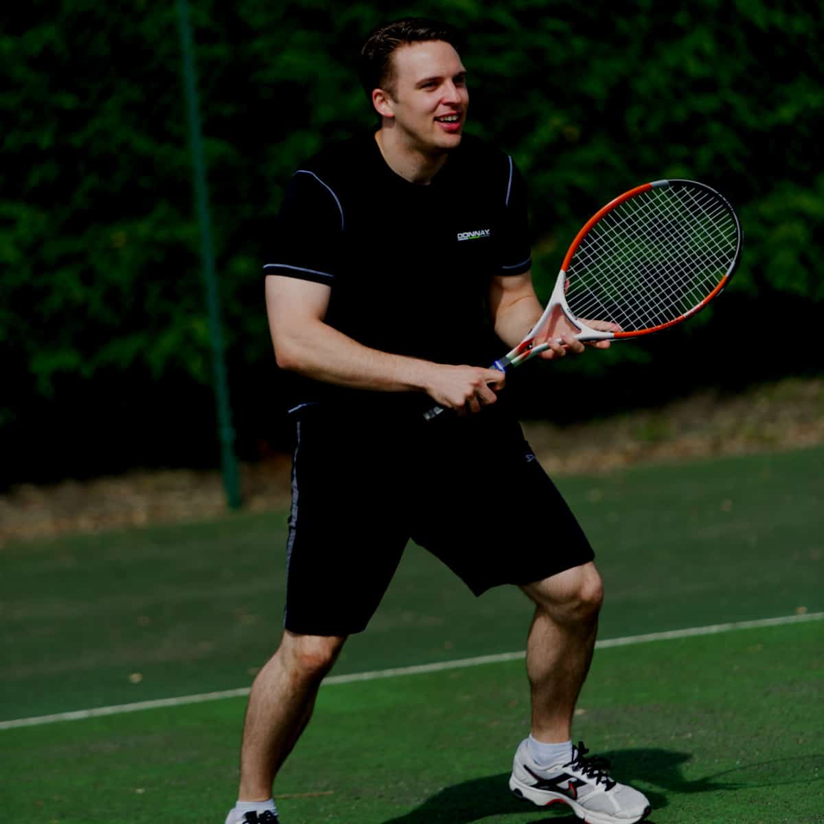 Man playing tennis in the dark