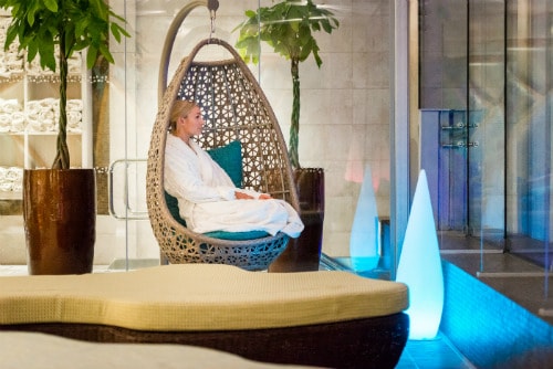 Guest looking at view from roof top seating area at night during spa hotel break