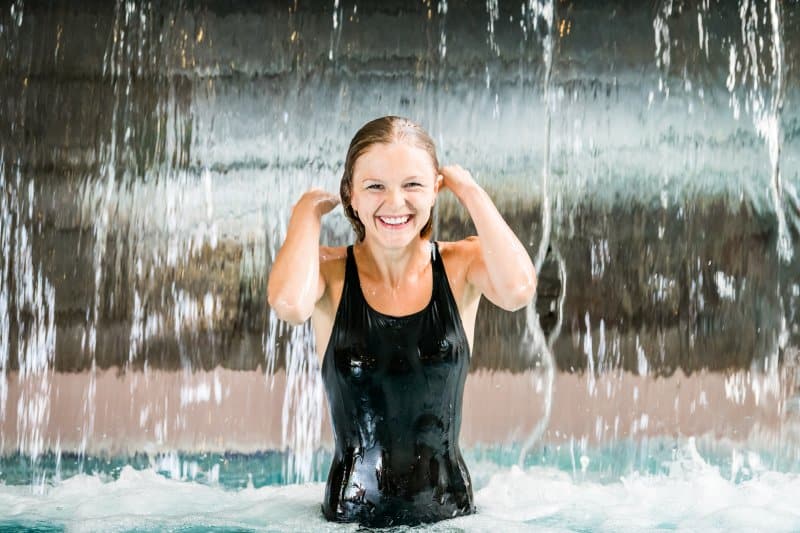 Lady smiling under the waterfall