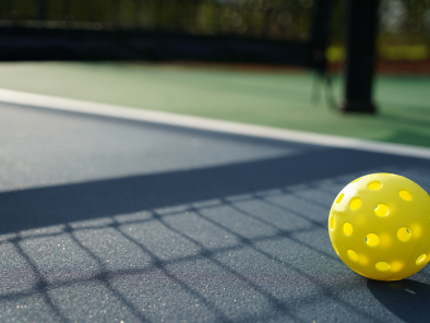 Close up of a pickleball on pickleball court.